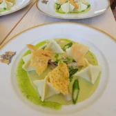 gold and white plates with ravioli and sauce